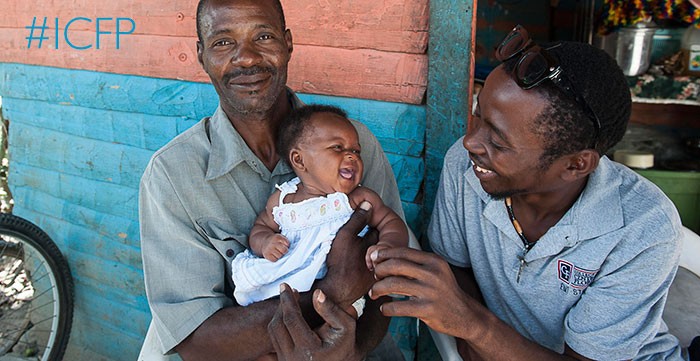 Two men in Haiti hold a baby