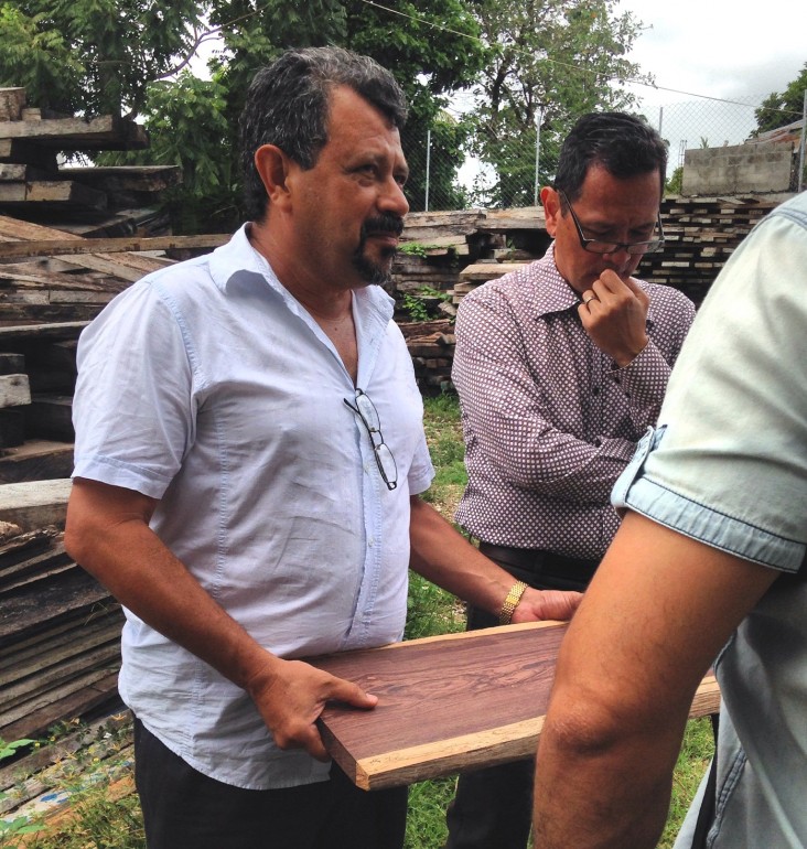 Alvaro Fernandino of USAID’s Security and Justice Sector Reform Project, in glasses, examines trafficked rosewood