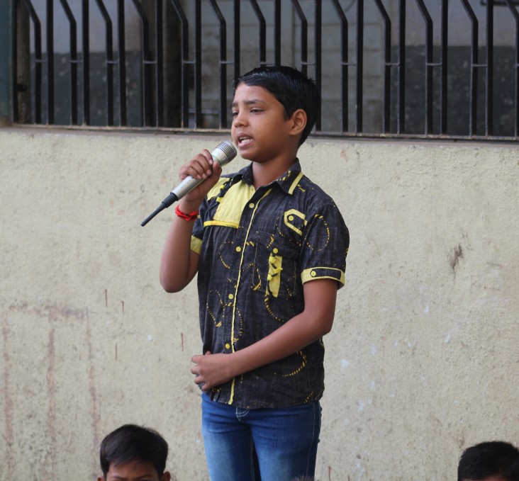 A student performs a song during the morning assembly at Kavi Kalidas Primary School.