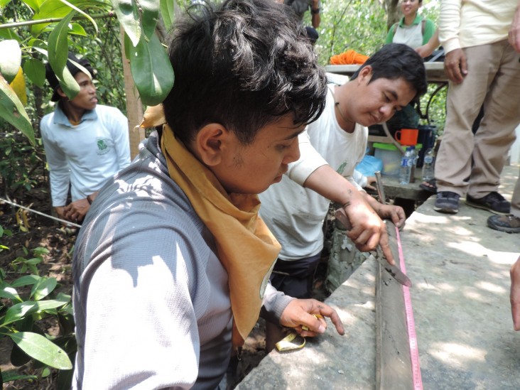 A USAID Yagasu carbon biodiversity research unit measures soil carbon content from an open-face auger in Indonesia.