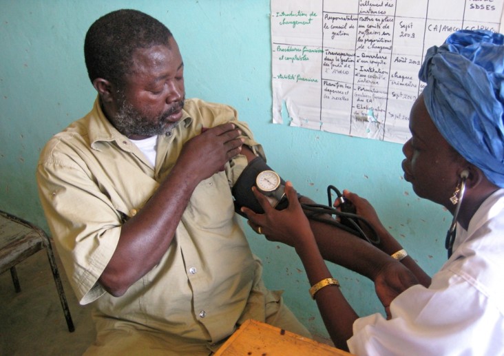 Malian community health worker trained by USAID checking blood pressure
