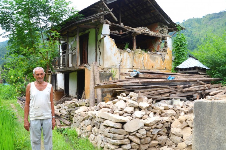 Farmer Rohini Prasad Kadariya, 74, stands next to his house in Ramechhap district destroyed by the first Nepal earthquake.