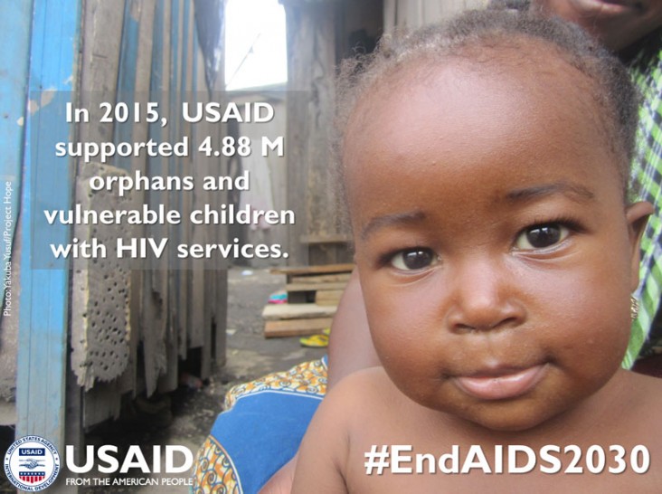 A baby looks at the camera. In 2015, USAID supported 4.88M orphans and vulnerable children with HIV services.
