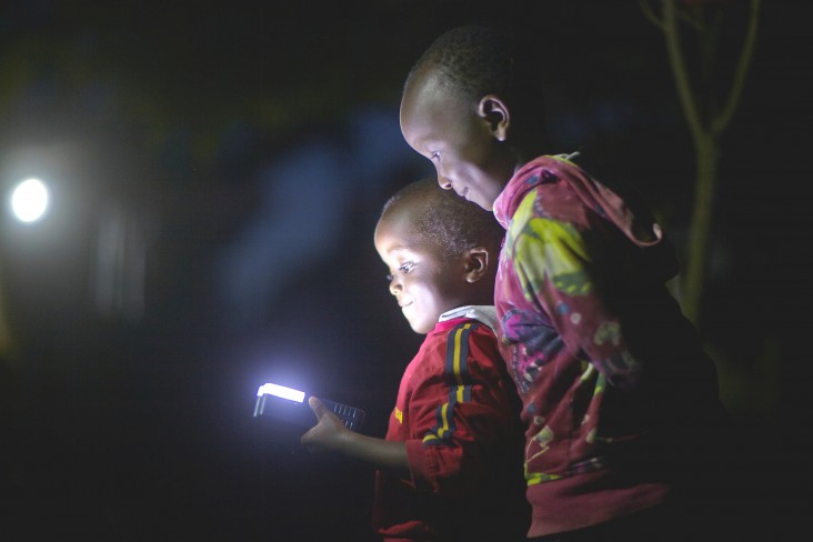 Children use a light powered by Off-Grid:Electric’s solar service, mPower.