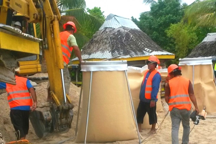 To quickly stop the erosion, workers filled geotextile bags with sand to place along the Manase coastline.