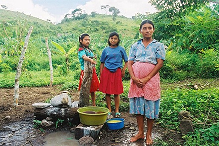A Mayan-Chortí woman and her daughters collect water at a standpipe in a village near Copan Ruinas, Honduras.