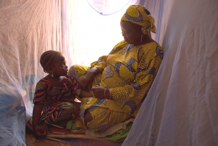 A Nigerian family uses protective malaria bed nets in their home.