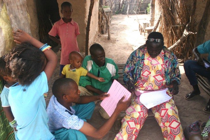 A community health worker reviews medical documents for Rougui Diallo’s family.