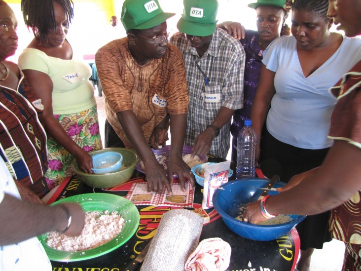 Women gather around bowls of cassava