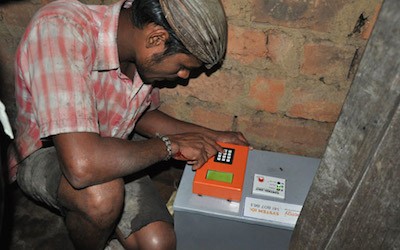 A man checks installation of a Simpa Networks household energy system.