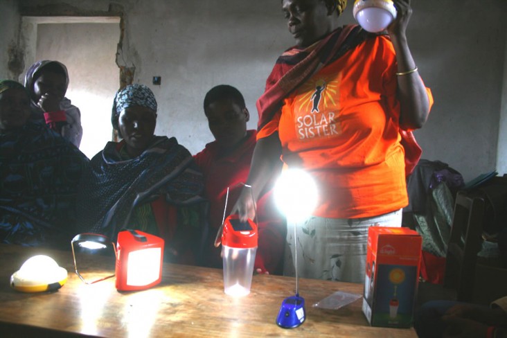 Solar Sister Valentina Tiem from Tanzania demonstrates products to other women in her community. Image: -Solar Sister, 2014 
