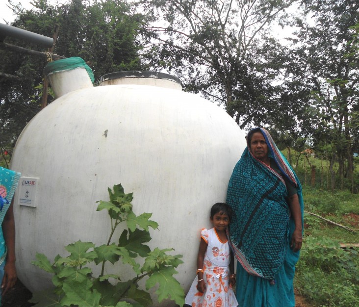 Abdulla Haleem’s wife and granddaughter in front of their rainwater system