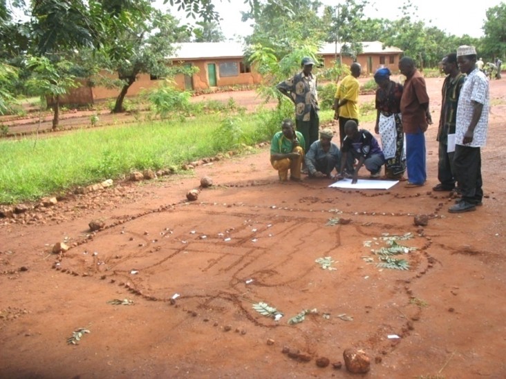 Villagers in Western Tanzania designate boundaries and landmarks using sticks and leaves to create a basic diorama of their vill