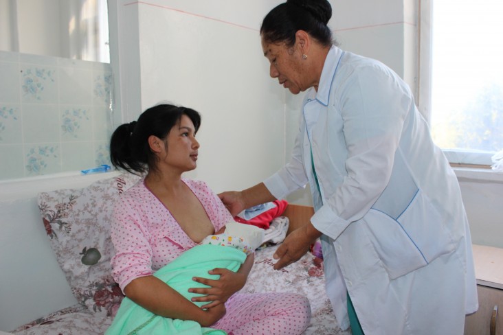 At the Jalal-Abad Oblast Merged Clinical Hospital, Chief Midwife Gulnara Maraimova counsels new mom Aida Yuldasheva on proper breastfeeding and the importance of skin-to-skin contact. 
