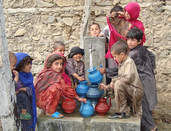 Children in Nawa, Afghanistan fill their containers with fresh running water.