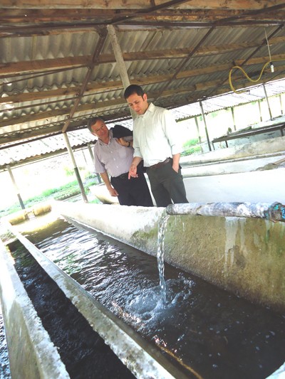Hamid Mikayilov (left), owner of the farm, shows a guest around his aquaculture facility.