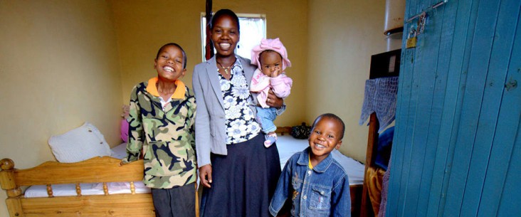 Tina, who is living with HIV, with her three children at her home in Tanzania. 