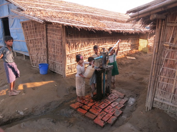 Displaced children using a water pump in Rakhine State, Burma.