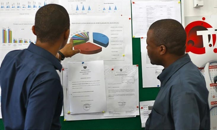Two men examine health program data in Mozambique.