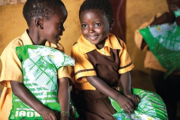 Photo of two young boys and their packets of mosquito nets