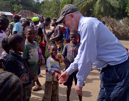 USAID Global Water Coordinator Christian Holmes congratulating children in forest community in Liberia