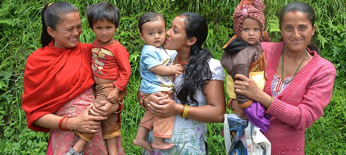 Three new mothers in Nepal hold their children