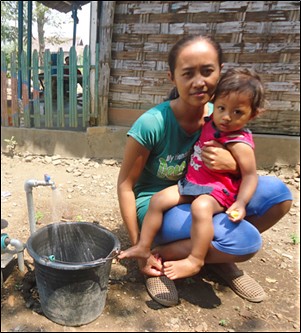 New piped water connection for Indonesian mother and child.