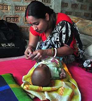 A community health worker assesses an infant