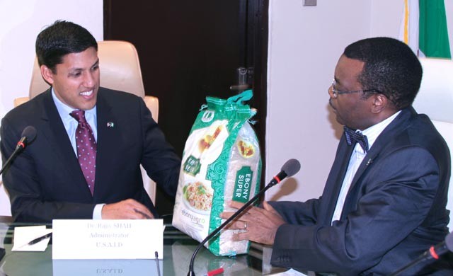 Dr. Akinwumi Adeshina Minister of Agriculture handing a bag of rice to Administrator Shah.