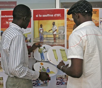 A Senegalese man discusses HIV/AIDS information tools with a representative of a USAID implementing partner.  