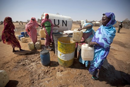 Women collect water from a tank installed by the African Union-United Nations Hybrid Operation in Darfur