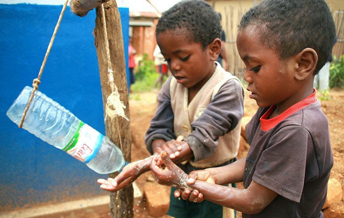 Children in Madagascar use the low cost, low tech, water-conserving ”tippy tap” to wash their hands