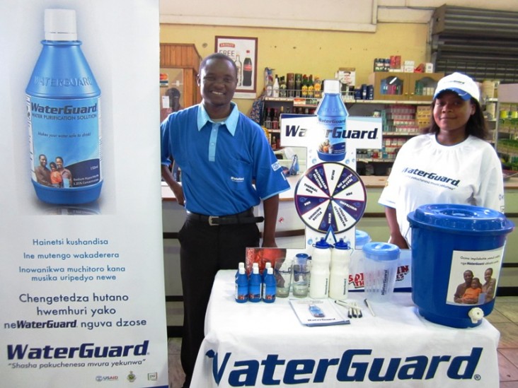 In a supermarket in Harare, Zimbabwe, two community outreach members stand at a display promoting WaterGuard