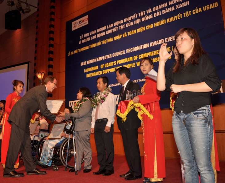 USAID Mission Director Joakim Parker awards employees with disabilities.