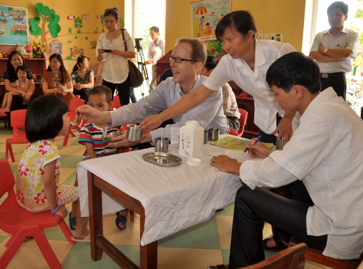 Giám đốc USAID Việt Nam Joakim Parker cho trẻ uống thuốc tẩy giun tại một trường mầm non của tỉnh Nam Định.