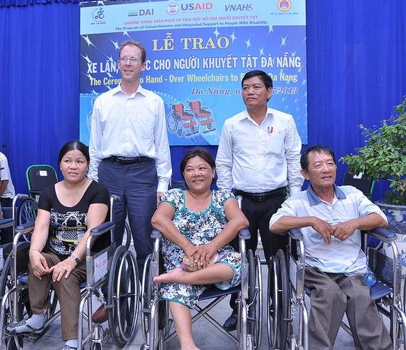 USAID Mission Director Joakim Parker, second from left, helps hand over wheelchairs to people with disabilities in Danang.