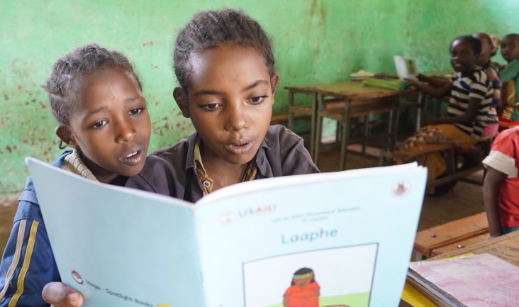 Two girls in a second grade class at the Soyama Primary School practice reading with one of the new supplementary books.