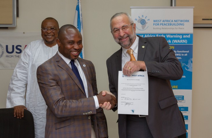 Chukewuemka Eze of WANEP and Alex Deprez of USAID at the signing of their new agreement to prevent election violence