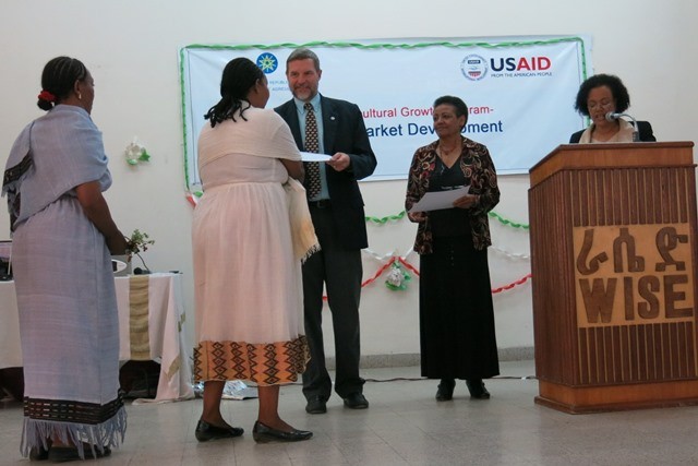 USAID representative Gary Robbins presents awards to the new graduates.