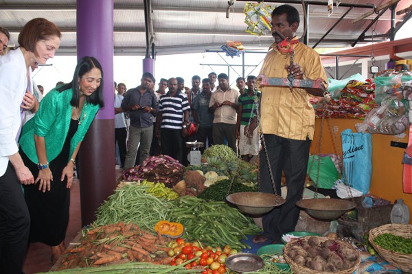 Ambassador Sison and USAID Mission Director Carlin speak to a vegetable vendor during the public market opening in Mullaitivu