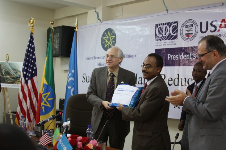 Ambassador Booth presents a mosquito net to Minister Kesetebirhan