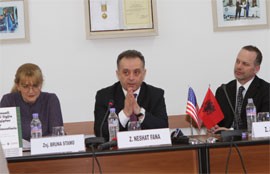 A man delivers remarks at a table