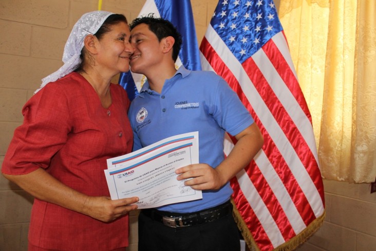 Naín Ezequiel Arriaza, uno de los beneficiarios del programa, besa a su madre después de su graduación.