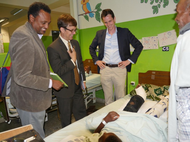 Chargé d'Affaires Peter Vrooman and hospital staff talk with a patient.