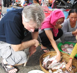 PEER researchers in Vietnam examine a fish catch at a local market.