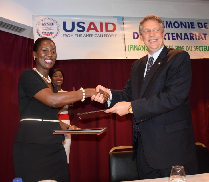 Gwendoline Abunaw and Matthew Smith shaking hands at the announcement of the partnership between USAID and Ecobank Cameroon.