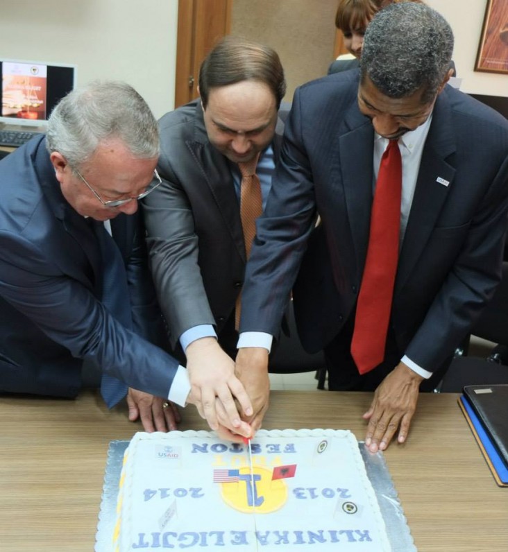 Three officials cut a cake