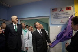 Two men unveil commemorative plaque at a hospital