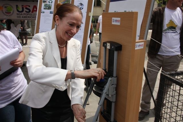 US Charge D'Affaires Kelly Degnan tests the bottle crusher on Earth Day
