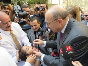 Egyptian Minister of Health and Population Dr. Adel Al Adawy vaccinates a child against polio.